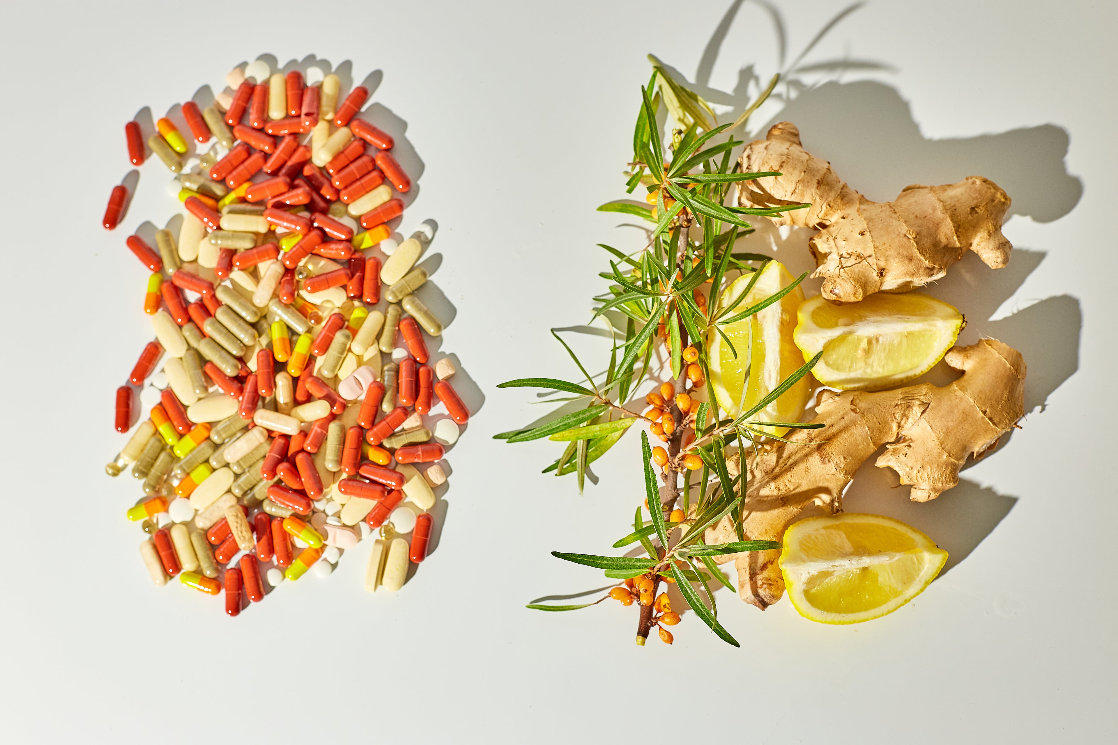 Herbal supplements, ginger, lemon, and colorful capsules on a white background representing gut health, digestion, and immune support.